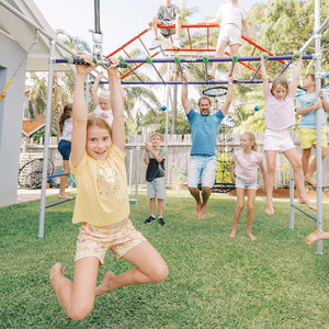 Family playing on Monkey Bars Frame while child swings on a flying fox